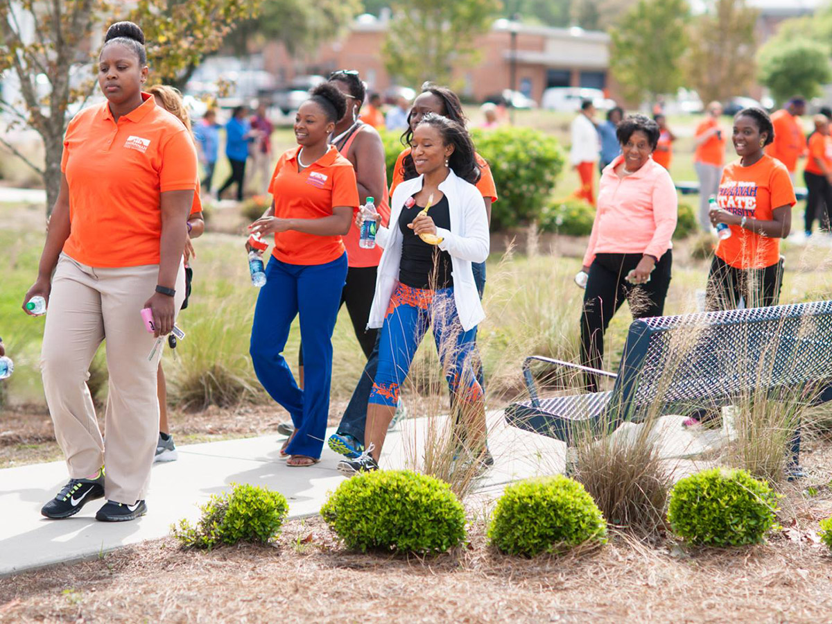 Savannah State University employees with fruit and walk bottles walking on campus.